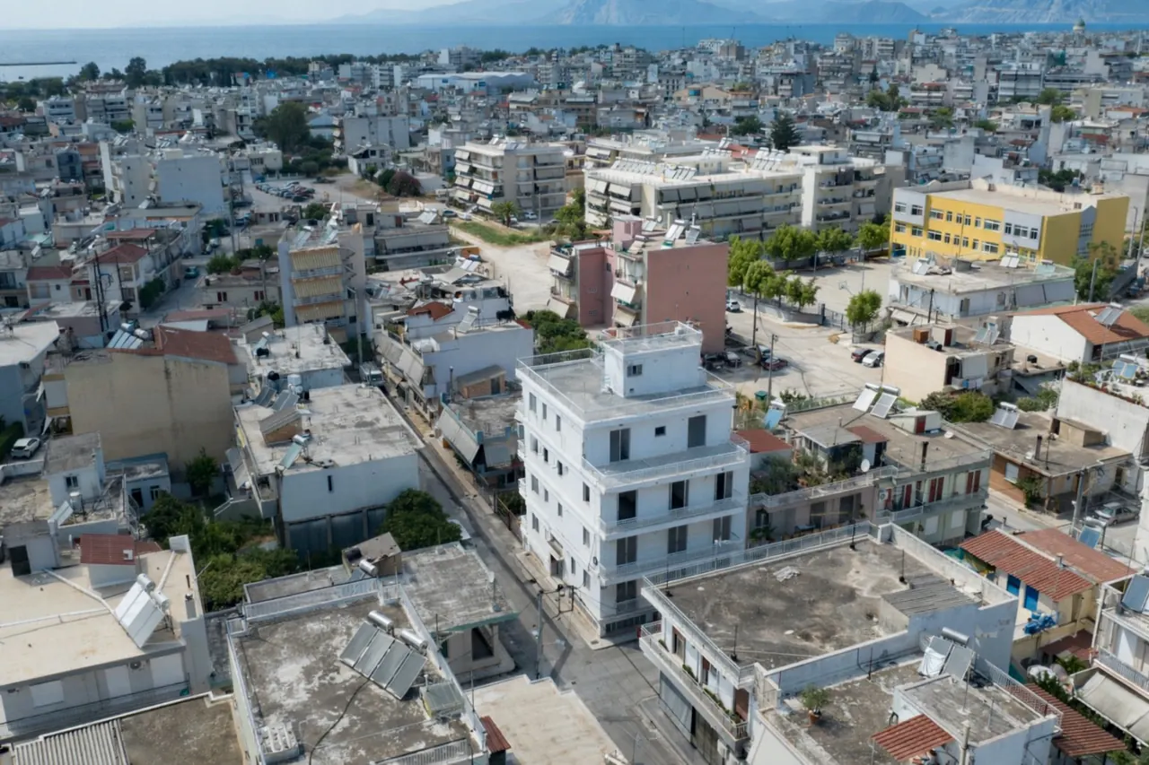 Drone photograph of the existing MVR 19 building among the surrounding blocks of south Patras